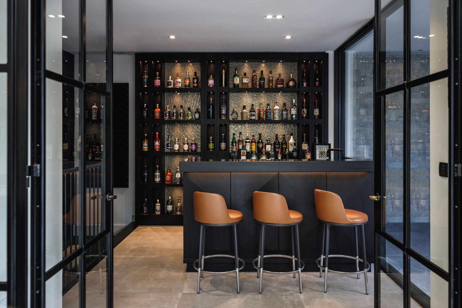 Stylish bar interior by Bamoo featuring bamboo-inspired finishes, custom bar counters, ambient pendant lighting, high stools, and rich textures—creating a luxurious, warm, and contemporary lounge atmosphere.